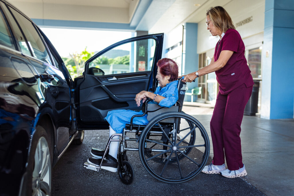 Pflegerin unterstützt Seniorin beim Einsteigen ins Auto – mobile Pflege und Betreuung im Einsatz